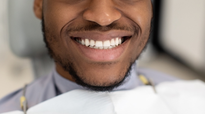 unrecognizable-black-man-widely-smiling-with-his-p-5AKCUA8