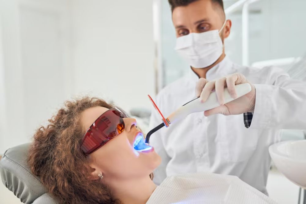 dentist performing professional teeth whitening treatment